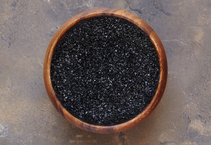 Granular activated carbon in a wooden bowl