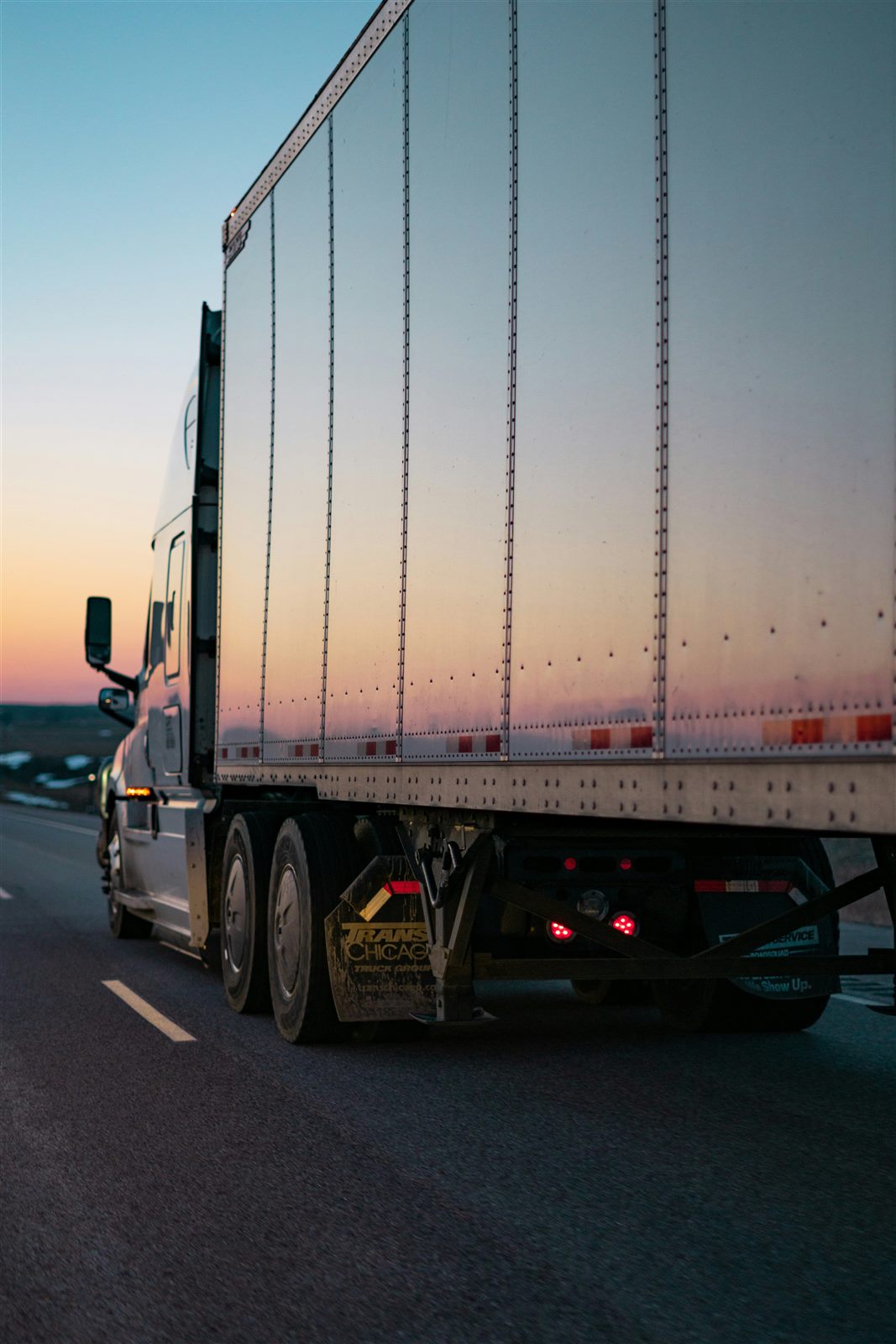 Freight truck transporting industrial products at dusk