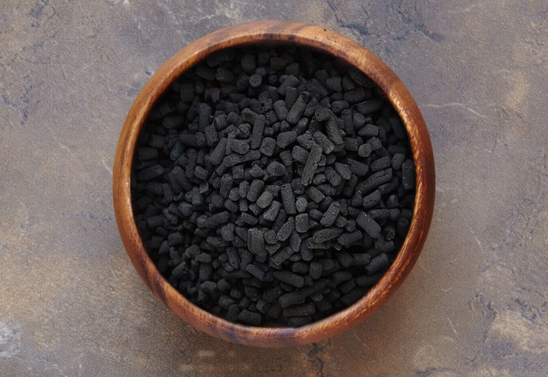 Pellet activated carbon in a wooden bowl