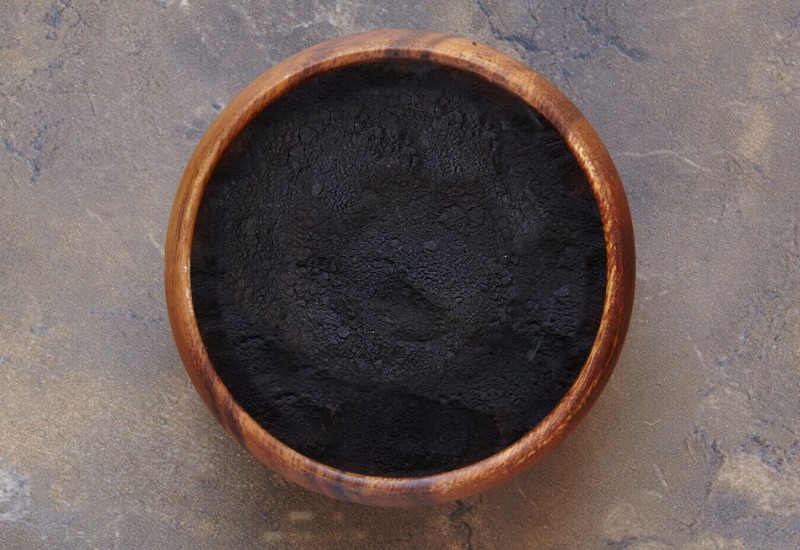 Powder activated carbon in a wooden bowl